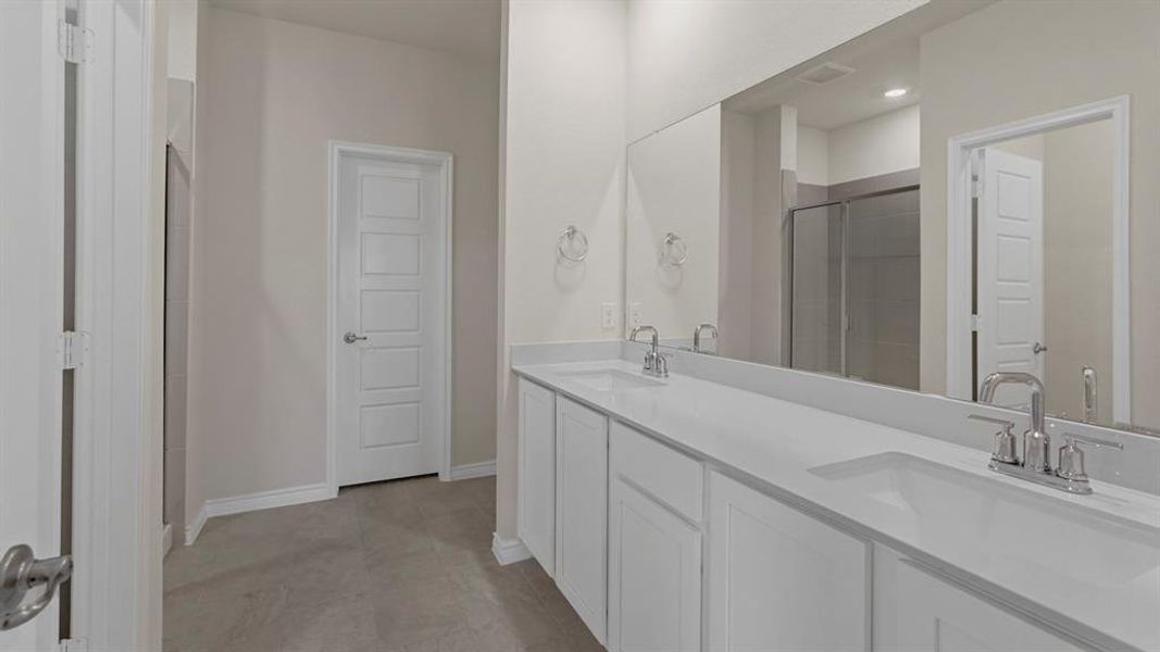 Double vanity with integrated sinks, white countertops, and chrome fixtures