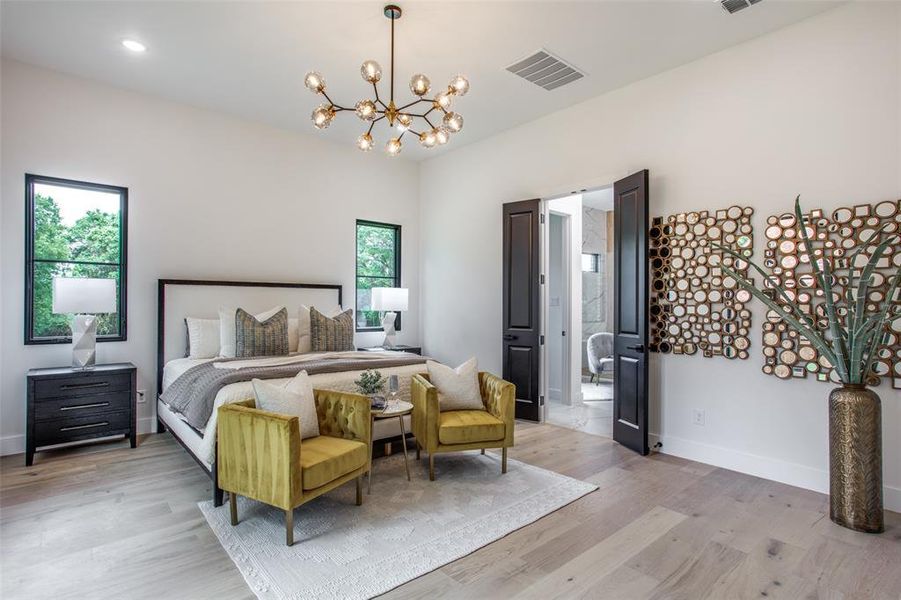 Bedroom with a notable chandelier and light hardwood / wood-style floors