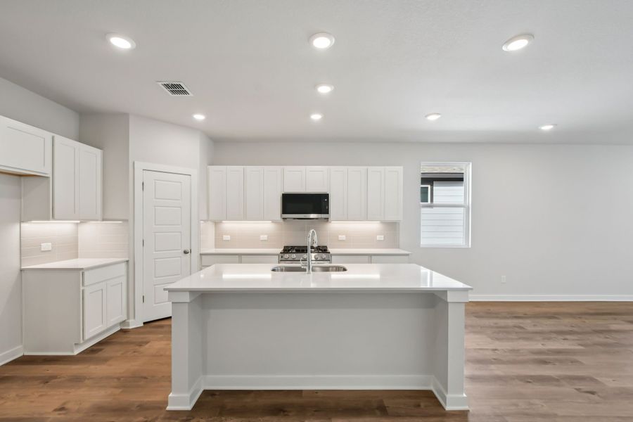 A kitchen with white cabinets.