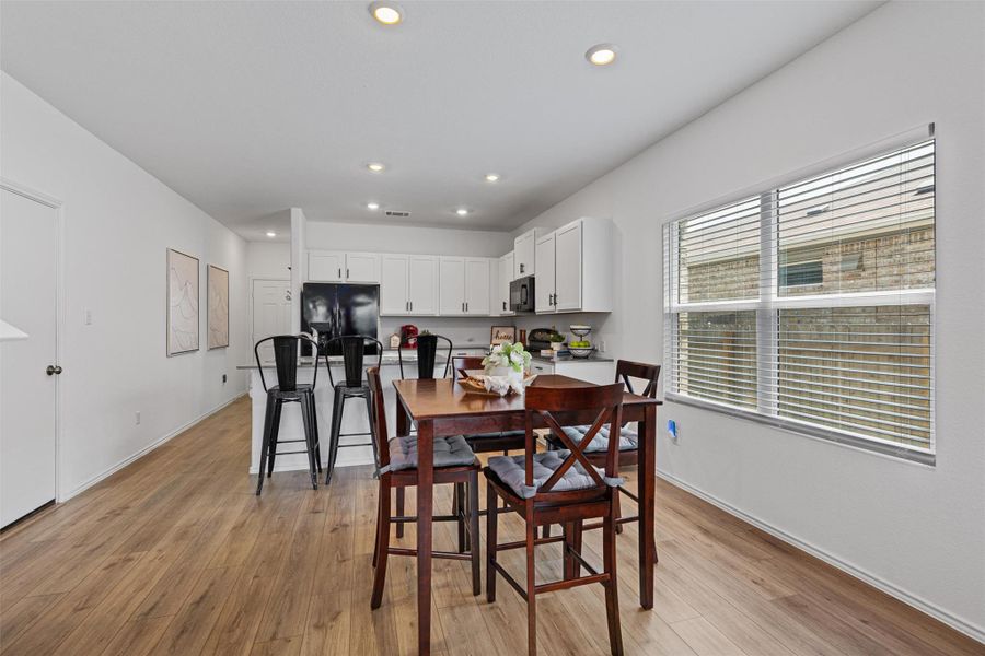 Dining space with light wood finished floors and recessed lighting