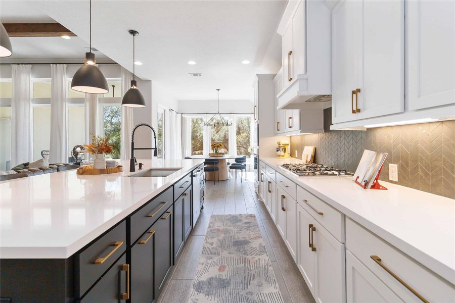 Kitchen with white cabinets, decorative light fixtures, backsplash, recessed lighting, and light stone countertops Kitchen with white cabinets, decorative light fixtures, backsplash, recessed lighting, and light stone countertops