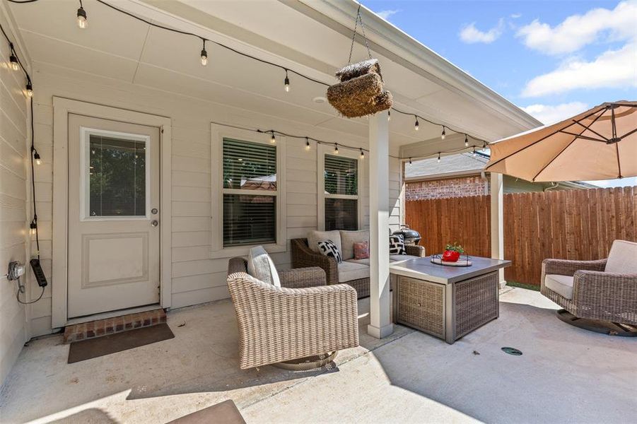 Relax and entertain on the covered back patio featuring string lights, sitting area, and extended outdoor living space. Relax and entertain on the covered back patio featuring string lights, sitting area, and extended outdoor living space.