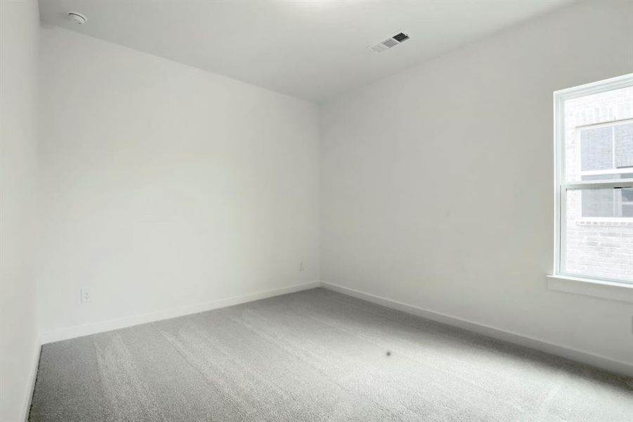 Bright interior room featuring a single window and light grey carpeting