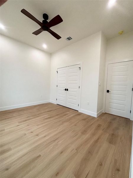 A spacious room features a rich wood-toned ceiling fan and durable wood-look flooring. A spacious room features a rich wood-toned ceiling fan and durable wood-look flooring.