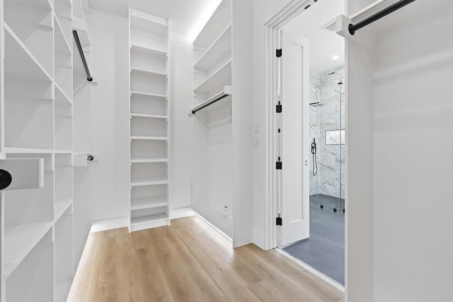 Walk in closet featuring light wood-style floors Walk in closet featuring light wood-style floors