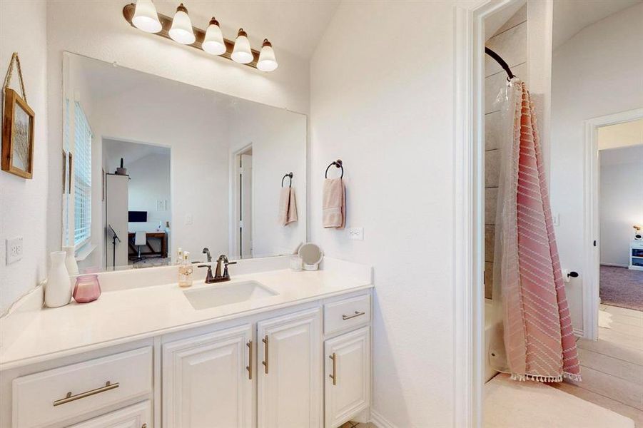 Full bathroom with vanity, shower / bath combo, and light tile patterned floors