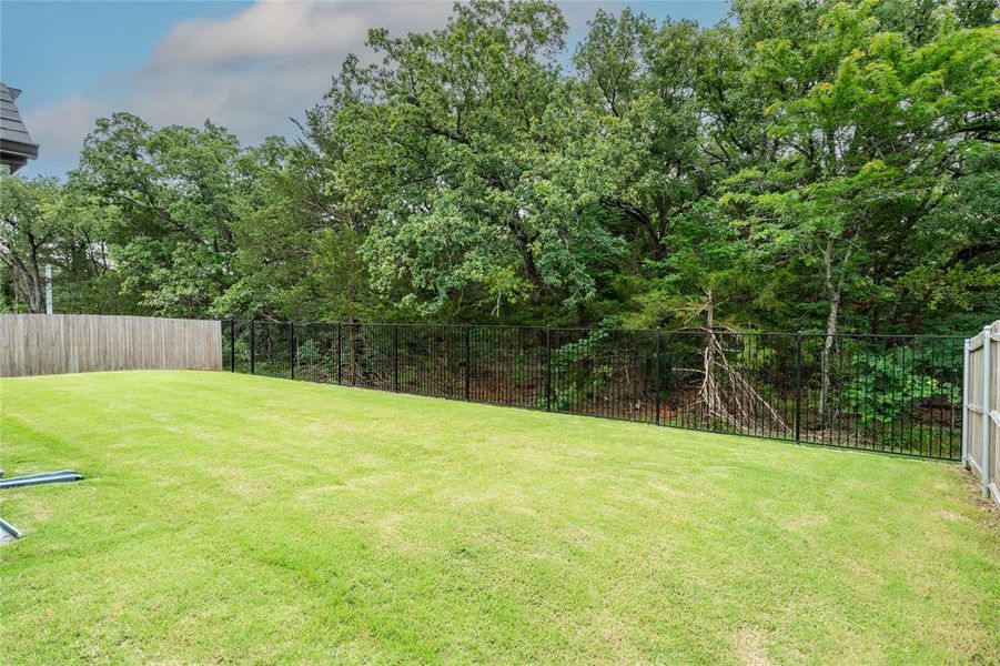 Large back yard with trees and beauty blocking out the rest of the world!