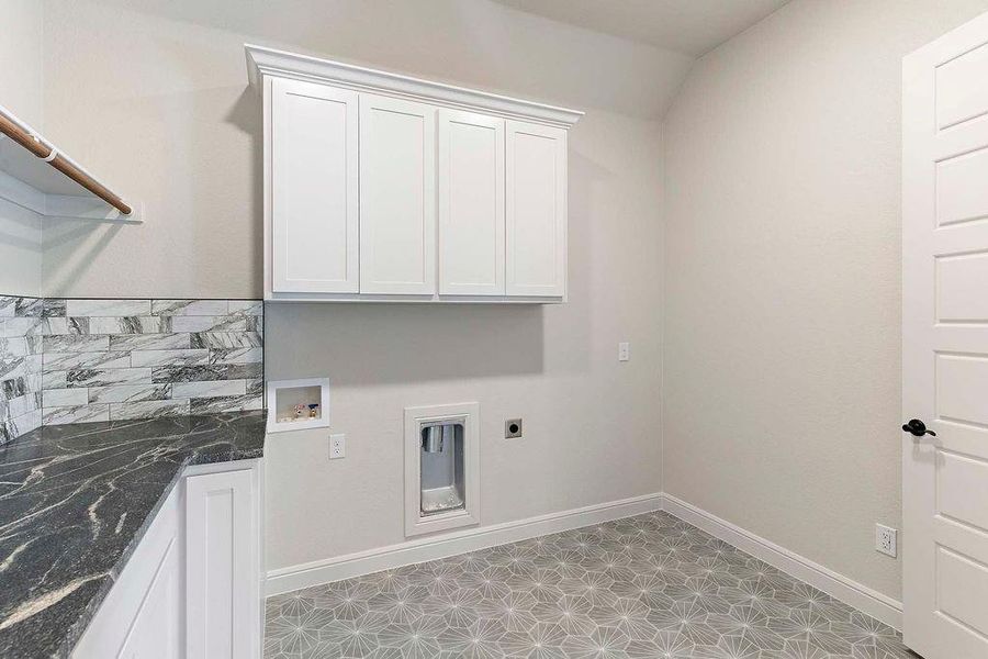 Laundry room with hookup for an electric dryer, washer hookup, and cabinet space