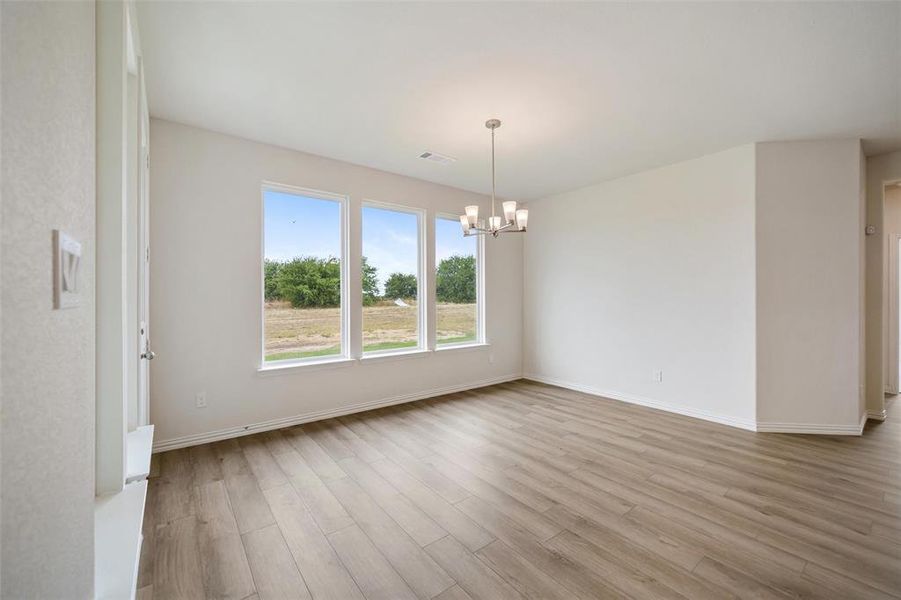 Unfurnished dining area with light wood-style flooring and a chandelier