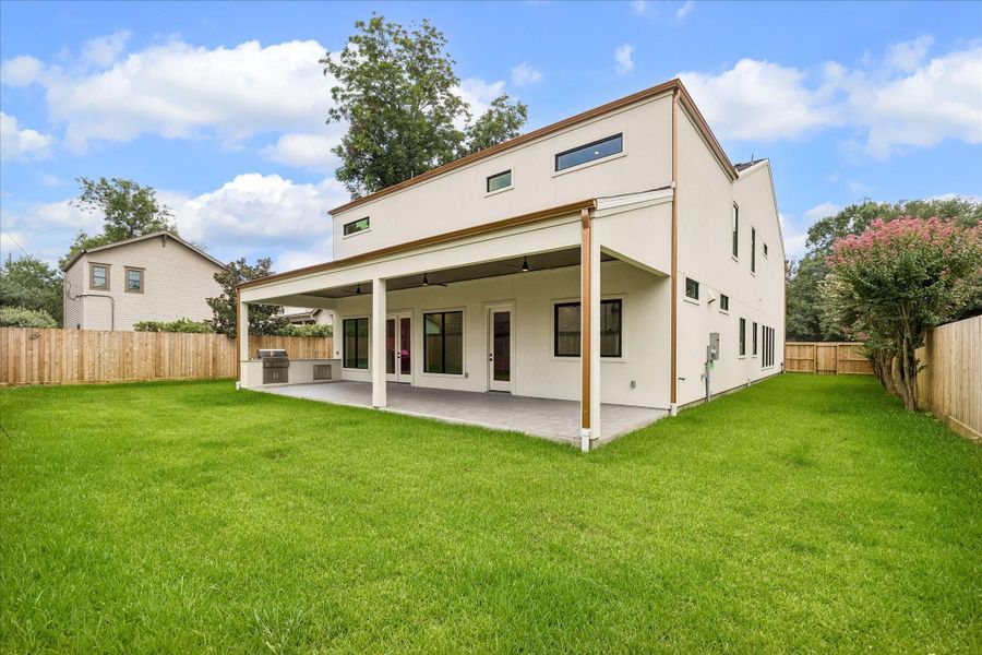 Wide open green space pairs with a covered outdoor living area and built in kitchen for weekend cookouts and everyday enjoyment. The site plan allows room for a future pergola with fireplace and pool bath alongside a 25x14 pool (upgrade option, ~$70,000), plus an 18' x 100' side yard for turf or added green space. A full drainage system with a commercial grade, square gutter upgrade keeps the yard as functional as it looks.