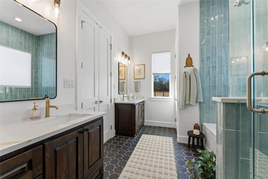 Bathroom featuring two vanities, a stall shower, and a tub to relax in