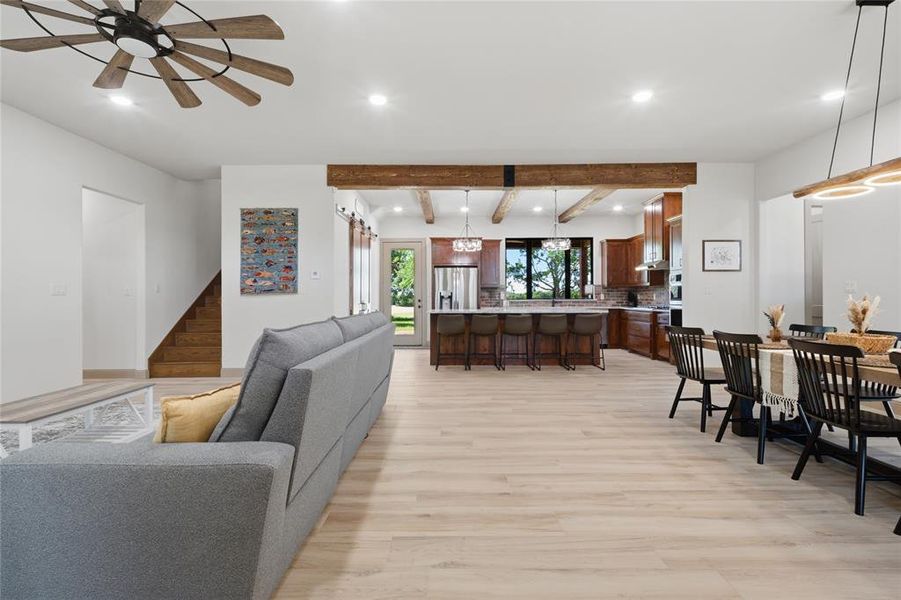 Spacious open-concept living area featuring light wood-finish flooring