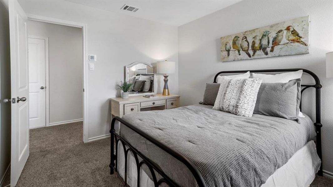 Bedroom with dark colored carpet and baseboards