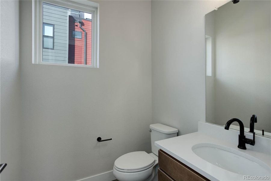 Main level powder bath tucked behind the dining room, next to the coat closet