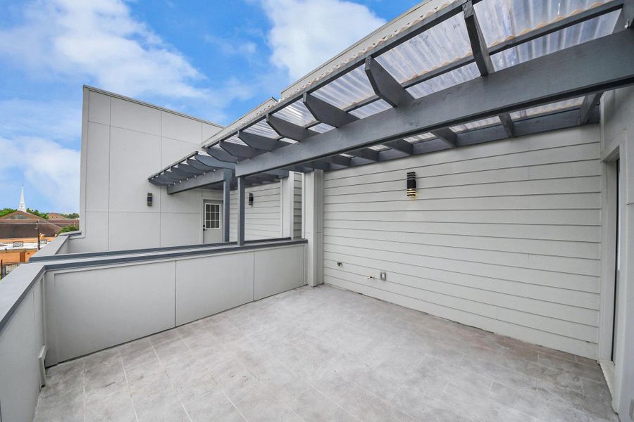 This photo showcases a spacious rooftop terrace with modern gray siding and a clear pergola, providing a stylish outdoor space with ample natural light. This photo showcases a spacious rooftop terrace with modern gray siding and a clear pergola, providing a stylish outdoor space with ample natural light.