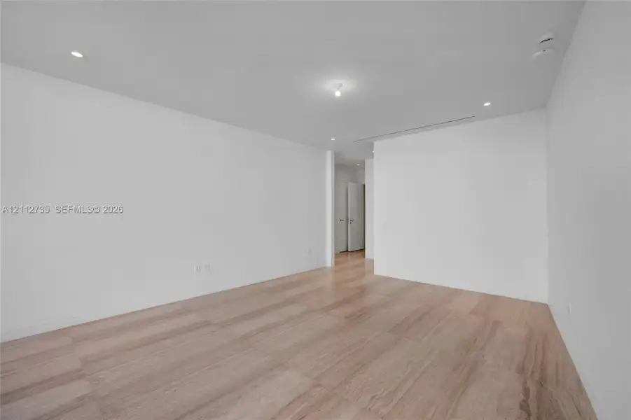 Minimalist interior featuring smooth walls, recessed ceiling lighting, and stone-finish flooring