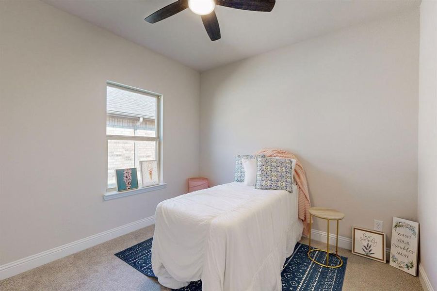 Carpeted bedroom featuring ceiling fan