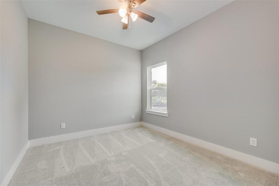 Unfurnished room featuring light carpet and ceiling fan