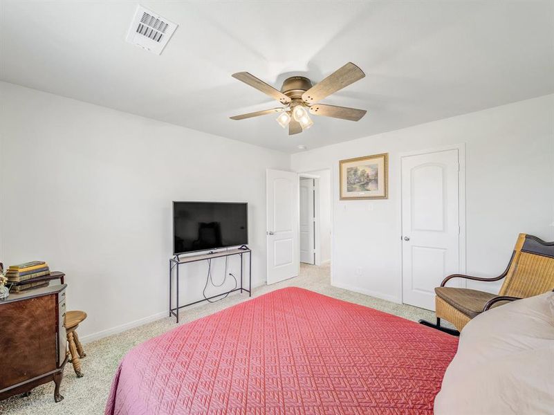 Carpeted bedroom featuring baseboards and a ceiling fan