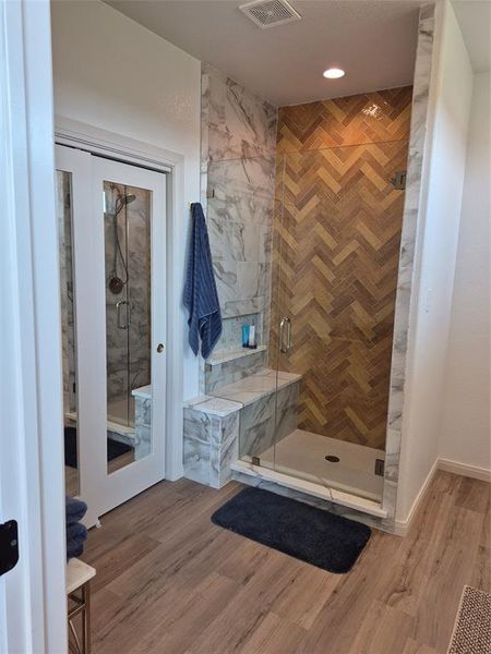 Full bath with light wood-style flooring, a shower stall, and recessed lighting