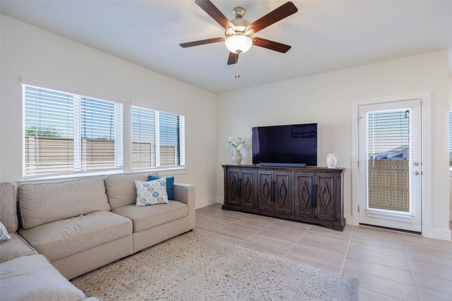 Living room featuring plenty of natural light, ceiling fan, and light tile patterned floors Living room featuring plenty of natural light, ceiling fan, and light tile patterned floors