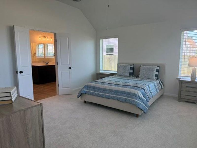 Carpeted room featuring a vaulted ceiling and dual windows with blinds