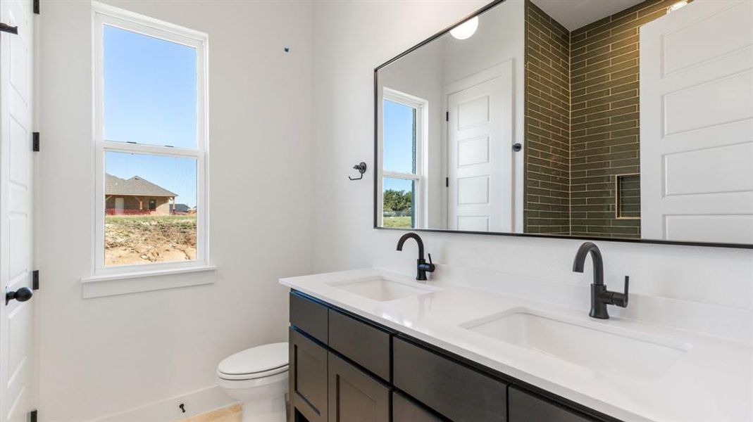 Bathroom featuring vanity, a healthy amount of sunlight, and toilet