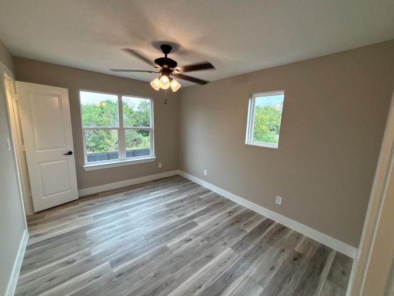 Unfurnished bedroom featuring light wood-style floors and a ceiling fan Unfurnished bedroom featuring light wood-style floors and a ceiling fan
