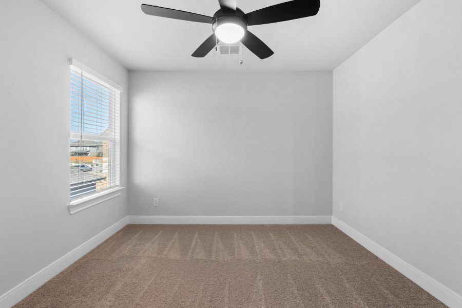 Spare room featuring carpet and ceiling fan