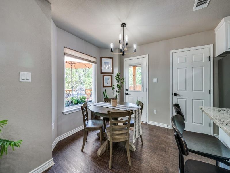 Dining space with a chandelier, baseboards, and dark wood finished floors Dining space with a chandelier, baseboards, and dark wood finished floors