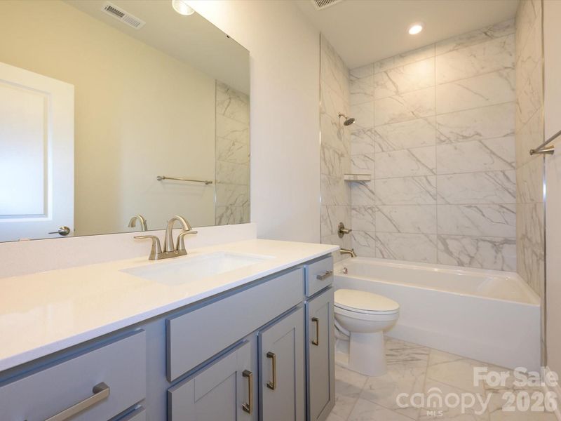 Secondary bathroom with tiled walls above the tub