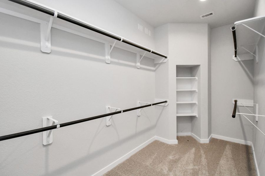 Walk-in closet that epitomizes luxury and practicality. This generously sized space features built-in shelving, offering abundant room for impeccable organization. High ceilings and recessed lighting create a bright and welcoming ambiance. Sample photo of completed home with similar floor plan. Actual colors and selections may vary. Walk-in closet that epitomizes luxury and practicality. This generously sized space features built-in shelving, offering abundant room for impeccable organization. High ceilings and recessed lighting create a bright and welcoming ambiance. Sample photo of completed home with similar floor plan. Actual colors and selections may vary.