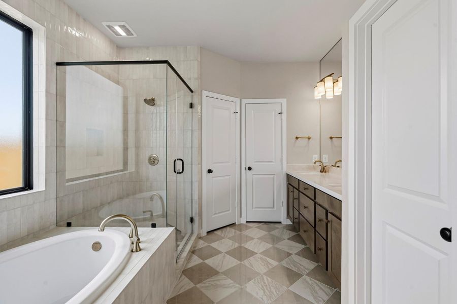 This spa-like bathroom shows off with remarkable, checkered tile flooring, polished tile to the ceiling, wood-tone cabinetry, and a glass enclosed main shower. This spa-like bathroom shows off with remarkable, checkered tile flooring, polished tile to the ceiling, wood-tone cabinetry, and a glass enclosed main shower.
