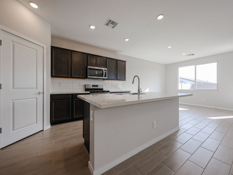 A kitchen with black cabinets. A kitchen with black cabinets.
