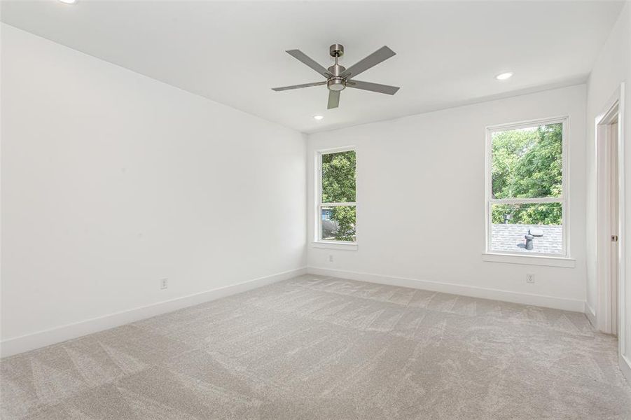 Unfurnished room with light colored carpet, healthy amount of natural light, baseboards, and recessed lighting