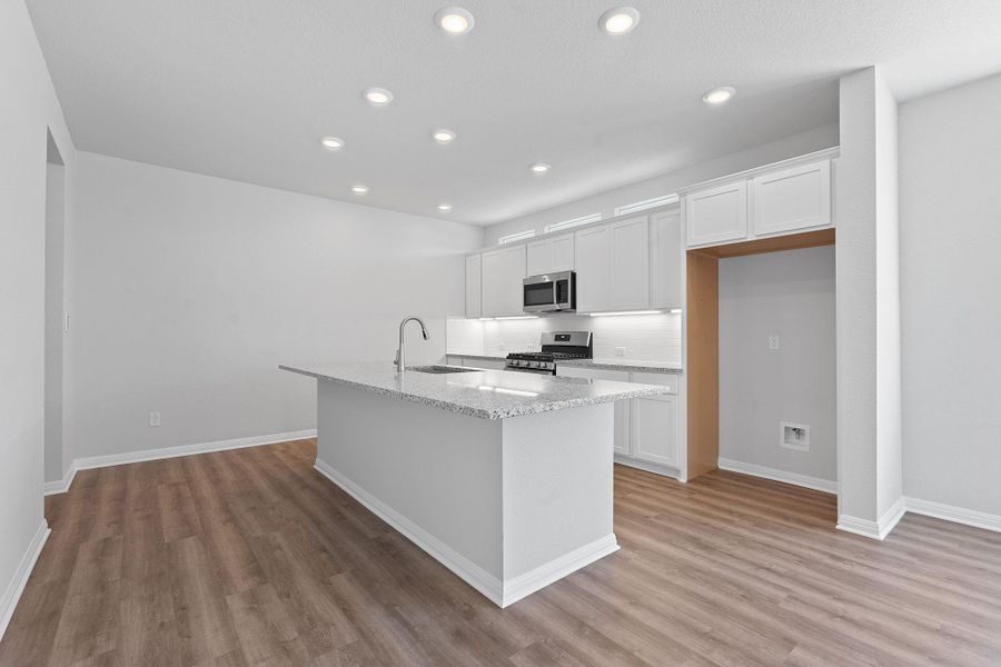 Kitchen featuring light wood-style floors, white cabinetry, appliances with stainless steel finishes, a center island with sink, and recessed lighting Kitchen featuring light wood-style floors, white cabinetry, appliances with stainless steel finishes, a center island with sink, and recessed lighting