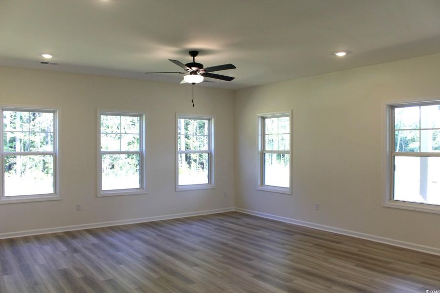 Empty room with recessed lighting, healthy amount of natural light, dark wood-type flooring, and ceiling fan Empty room with recessed lighting, healthy amount of natural light, dark wood-type flooring, and ceiling fan