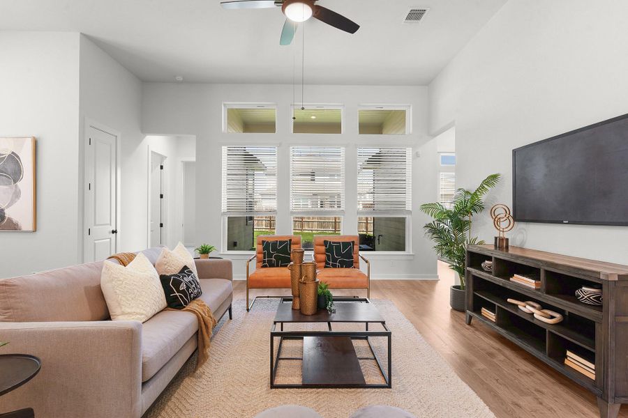 High ceilings and tall transom windows elevate this welcoming living space with warm wood floors.
