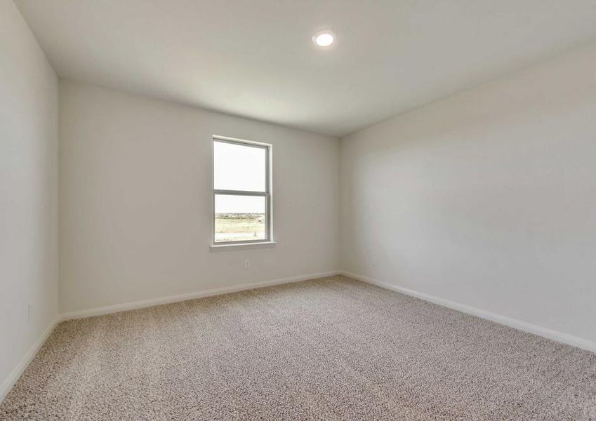 Secondary bedroom with white walls and brown carpet.