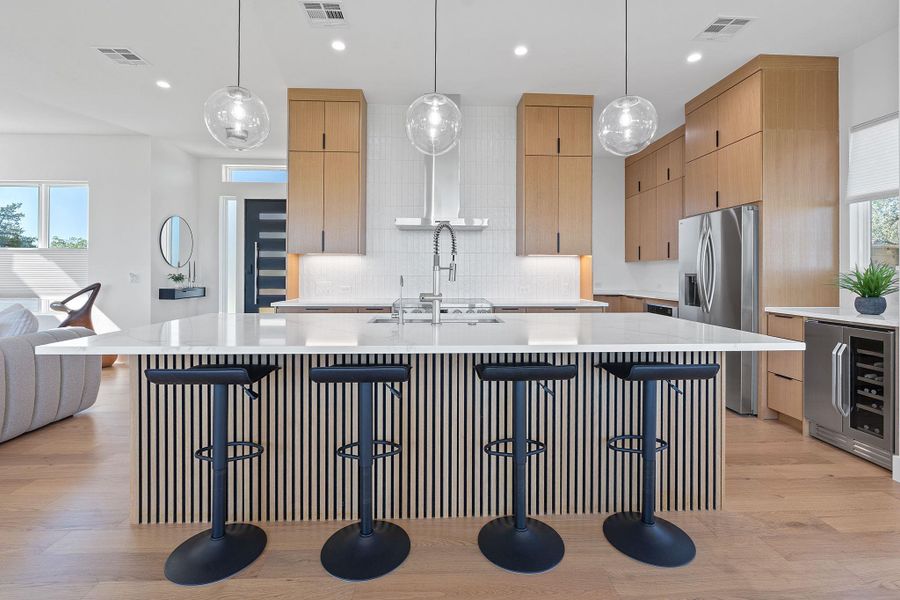 Clean lines, warm wood, and a show-stopping island open-concept space. Clean lines, warm wood, and a show-stopping island open-concept space.