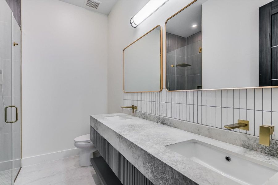 Full bath featuring a stall shower and double vanity Full bath featuring a stall shower and double vanity