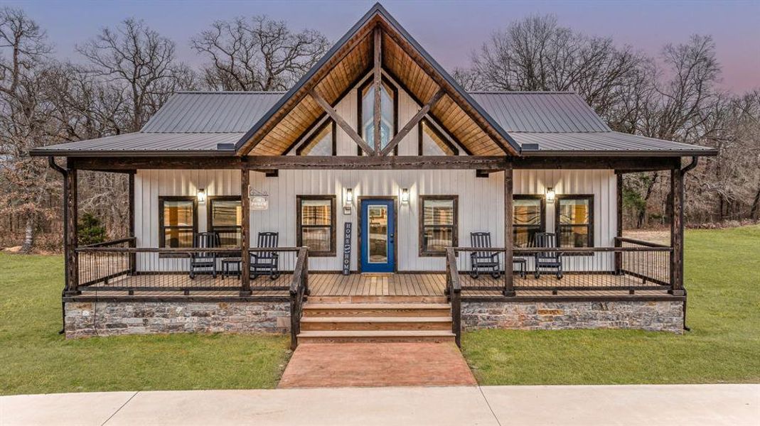 View of front of house featuring covered porch, a metal roof, a front lawn, and board and batten siding