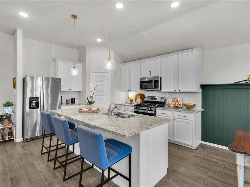 The gourmet kitchen is a true centerpiece of the home, equipped with sleek GE stainless steel appliances.