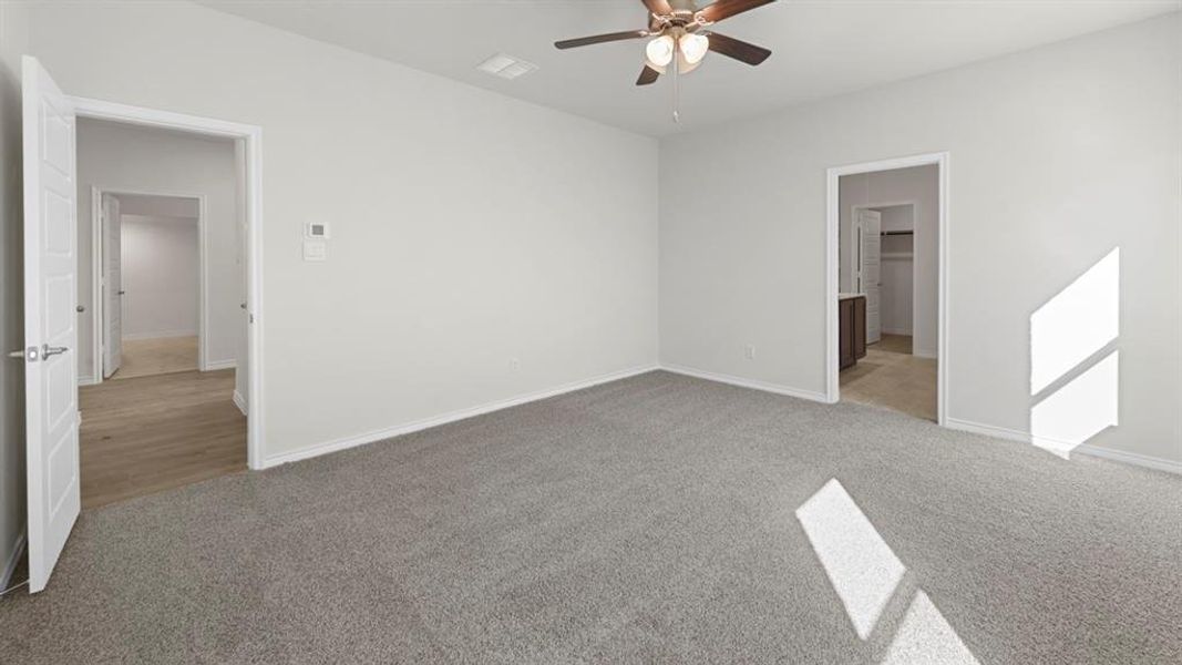 Spacious room featuring neutral carpeting, light gray wall paint, and a ceiling fan with integrated lighting Spacious room featuring neutral carpeting, light gray wall paint, and a ceiling fan with integrated lighting