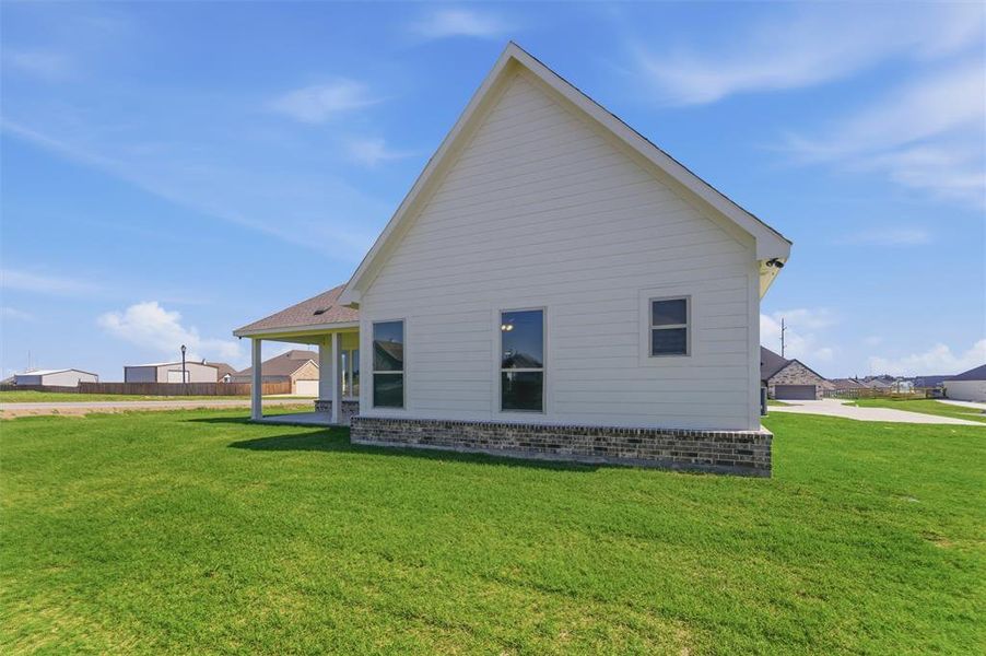 New construction exterior featuring white siding and a brick skirting