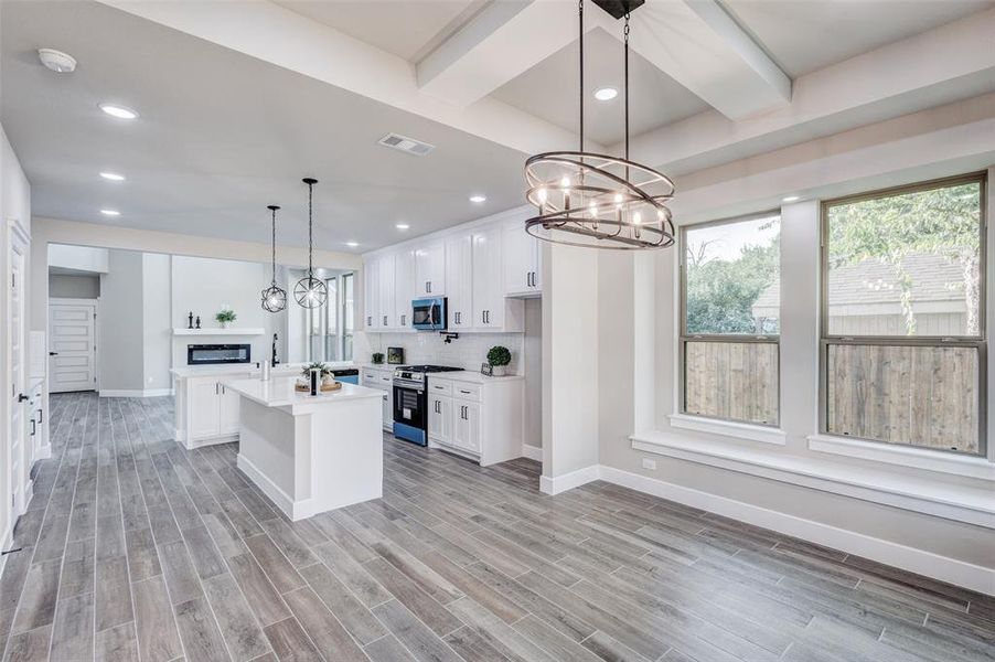 Kitchen with a chandelier, light countertops, light wood-style floors, healthy amount of natural light, and recessed lighting