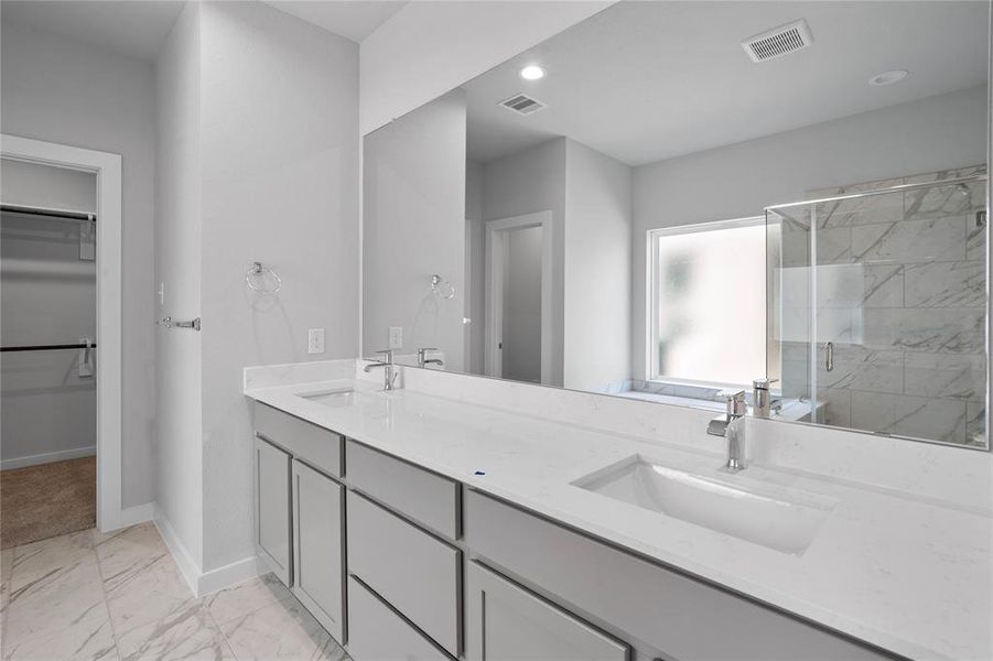 This primary bathroom is definitely move-in ready! Featuring light stained cabinets with light countertops, spacious walk-in closet with shelving, high ceilings, custom paint, sleek modern finishes.