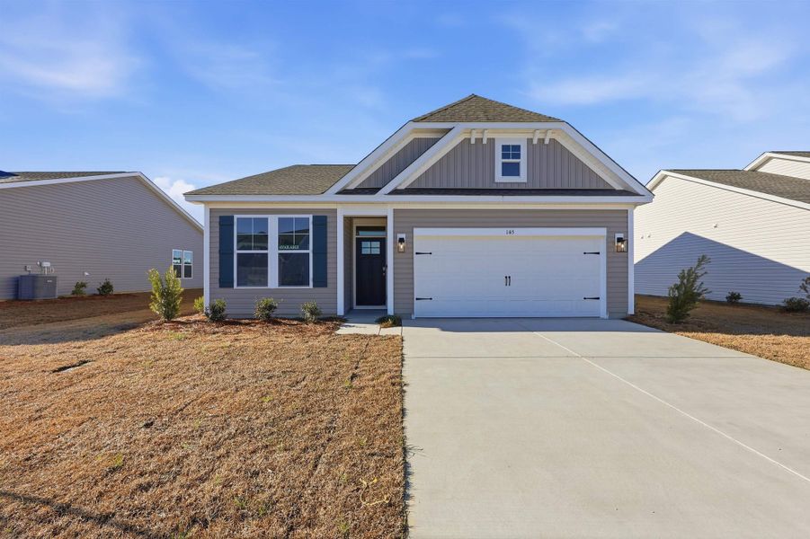 View of front of home with roof with shingles, driveway, board and batten siding, a garage, and a front yard View of front of home with roof with shingles, driveway, board and batten siding, a garage, and a front yard