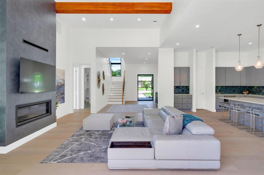 Living room featuring light wood finished floors, a fireplace, and recessed lighting