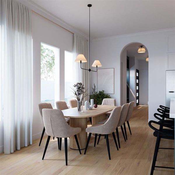 Dining area featuring arched walkways, light wood finished floors, and ornamental molding